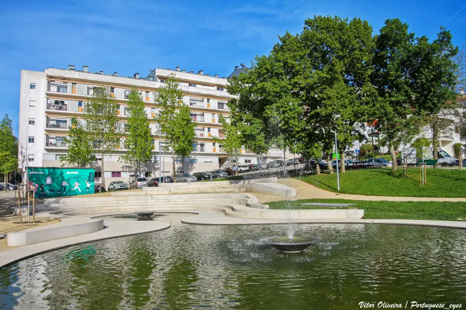 Espelho de água com repuxo, bancos de granito e árvores no Parque de Lazer de Marzovelos, em Viseu