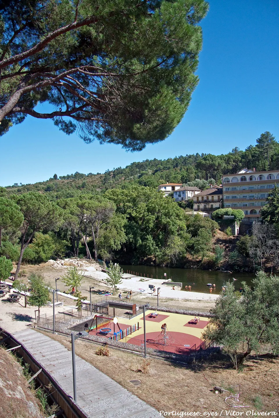 O parque e a praia fluvial do Banho, com o rio Dão e o hotel na encosta em frente