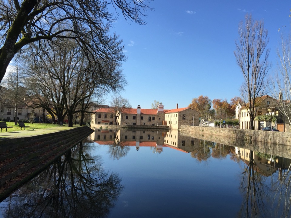 Edifício de granito da Casa da Ribeira junto ao Rio Pavia e ponte de pedra em Viseu